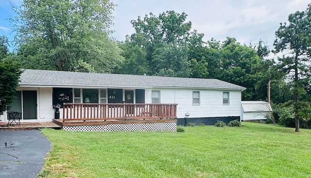 ranch-style house featuring a wooden deck and a front yard