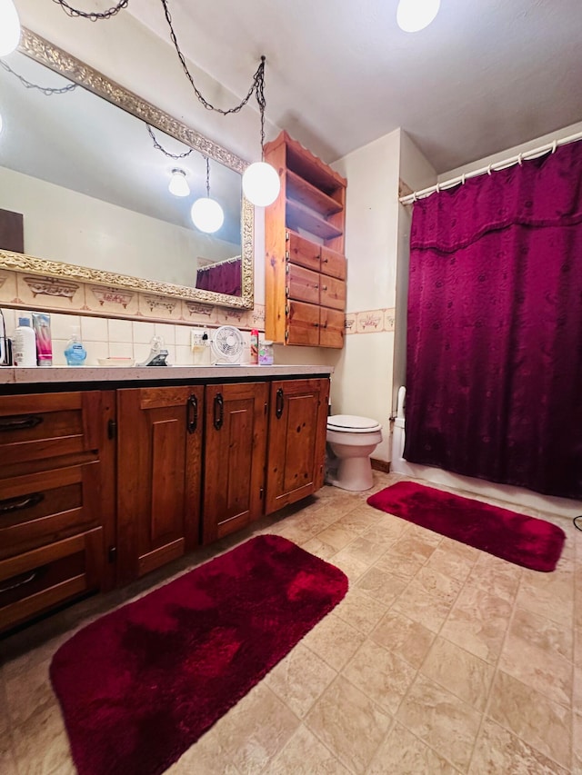 bathroom with vanity, toilet, and backsplash