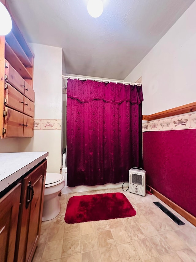 bathroom with curtained shower, vanity, and toilet