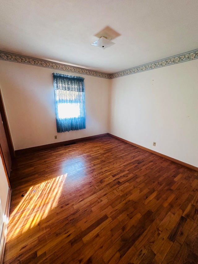 empty room featuring dark wood-type flooring