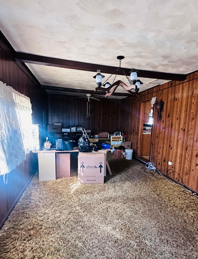 kitchen featuring beamed ceiling, carpet flooring, and wooden walls