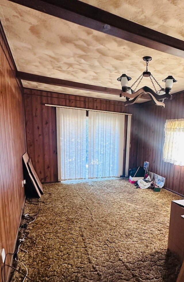 misc room with beam ceiling, wooden walls, and carpet flooring