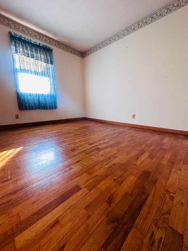 unfurnished room with wood-type flooring