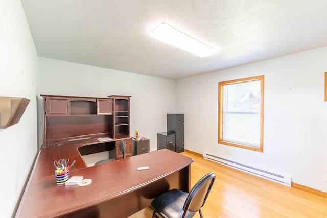 office featuring a baseboard heating unit, baseboards, and light wood finished floors