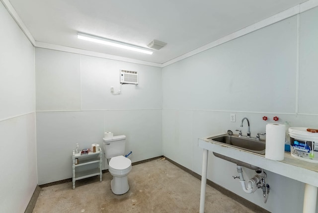 bathroom with sink, a wall unit AC, toilet, and concrete floors