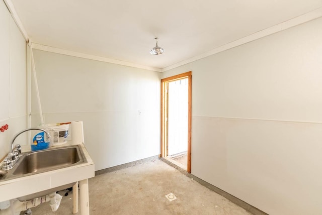 interior space featuring concrete flooring, a sink, and crown molding