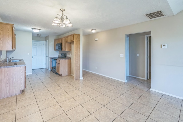 kitchen with an inviting chandelier, decorative light fixtures, sink, black appliances, and light tile patterned floors