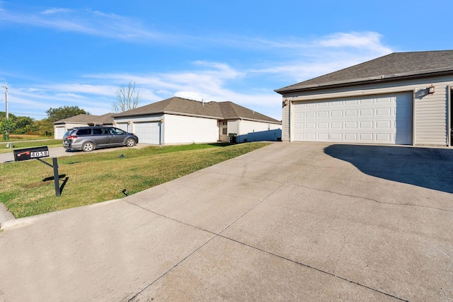 view of side of property featuring a yard and a garage