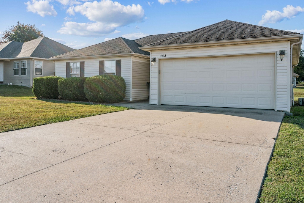 ranch-style home with a garage and a front yard