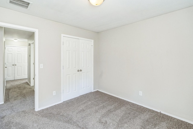 unfurnished bedroom featuring a closet and carpet flooring