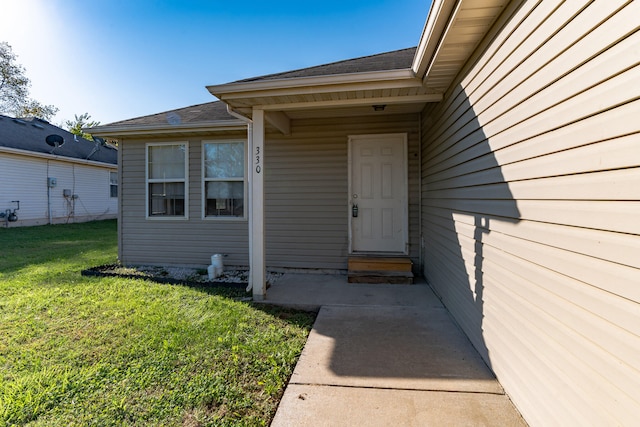 entrance to property featuring a lawn