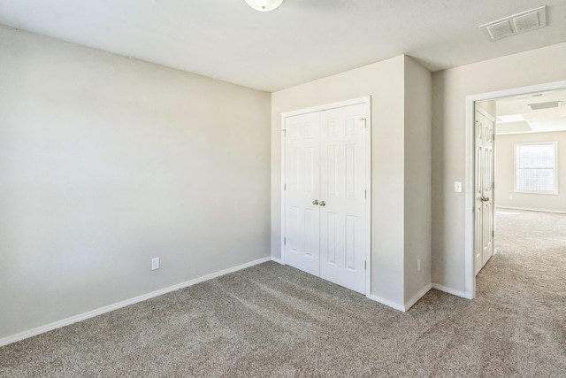 unfurnished bedroom featuring light carpet and a closet