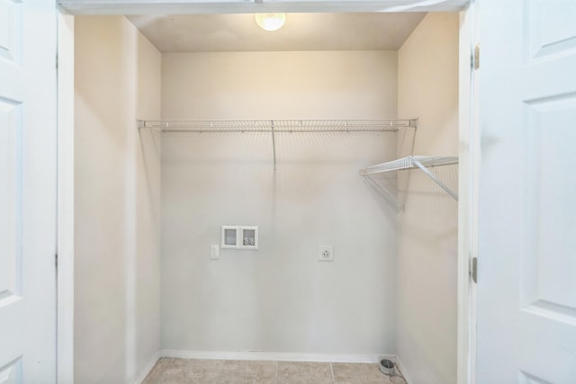 clothes washing area featuring light tile patterned flooring, hookup for a washing machine, and electric dryer hookup