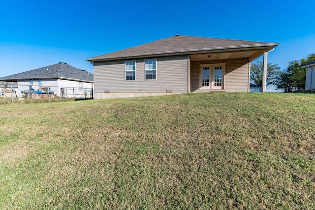 back of house featuring a yard and french doors