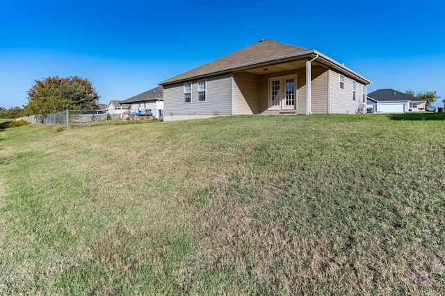 330 W Summit St, Aurora, MO 65605 - back of property featuring a lawn, fence, and french doors