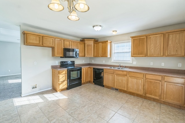 kitchen with light tile patterned floors, pendant lighting, sink, and black appliances