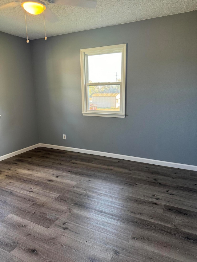 spare room with dark hardwood / wood-style flooring and a textured ceiling