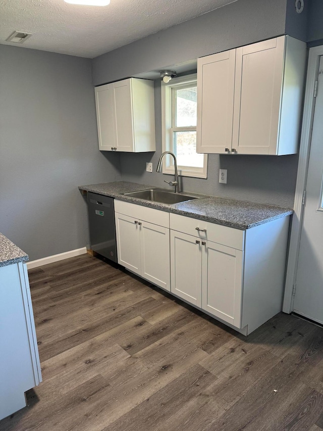 kitchen featuring dishwasher, white cabinetry, sink, dark hardwood / wood-style flooring, and a textured ceiling