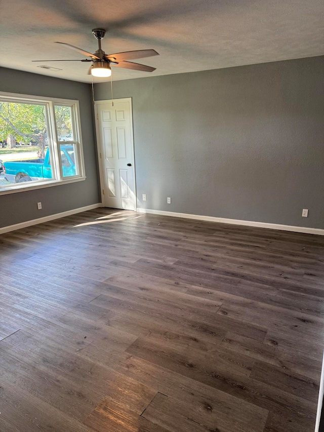 spare room with dark wood-type flooring and ceiling fan