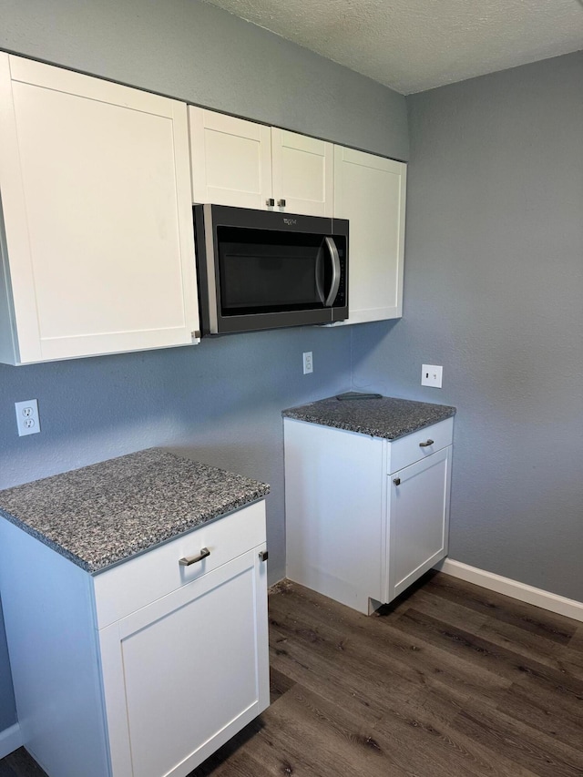 kitchen with white cabinetry, dark wood-type flooring, and a textured ceiling