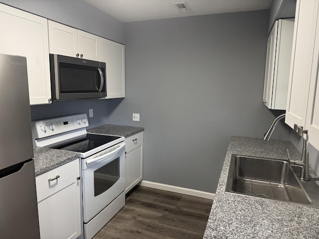 kitchen with stainless steel refrigerator, white cabinetry, sink, dark hardwood / wood-style flooring, and electric stove