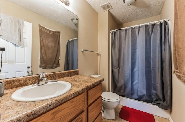 bathroom with vanity, toilet, curtained shower, and a textured ceiling