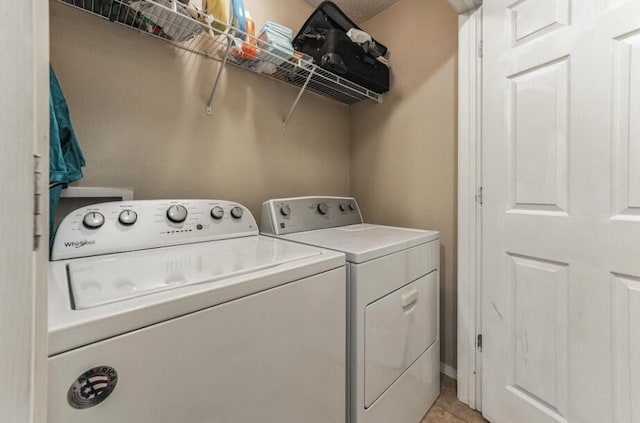 laundry room with washer and dryer and light tile patterned floors