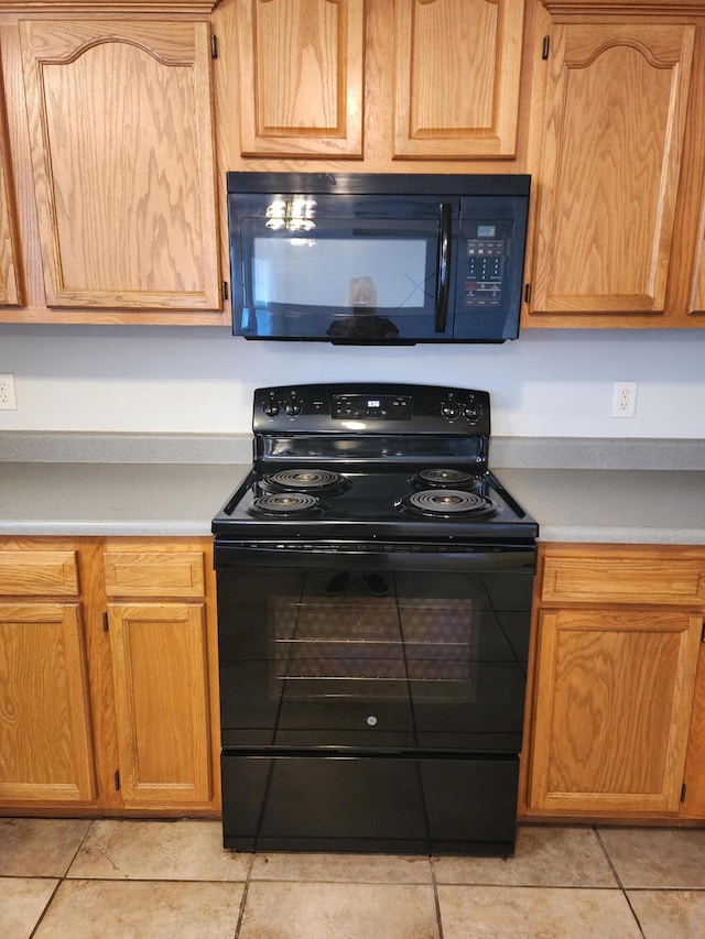 kitchen featuring light countertops, black appliances, and light tile patterned flooring
