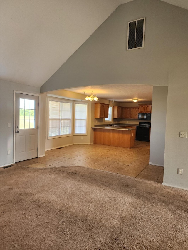 unfurnished living room featuring high vaulted ceiling, light carpet, a notable chandelier, and visible vents