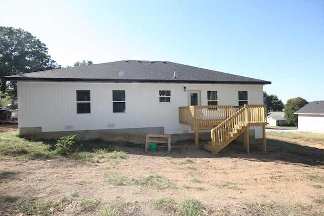 rear view of property featuring a wooden deck