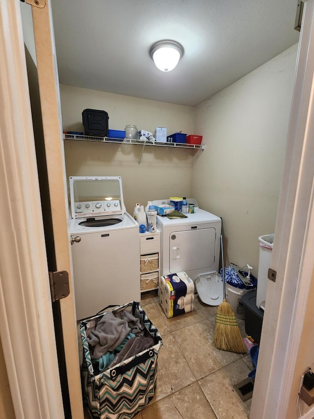 washroom featuring separate washer and dryer and light tile patterned floors