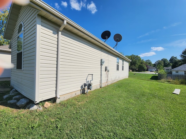 view of side of home with a yard