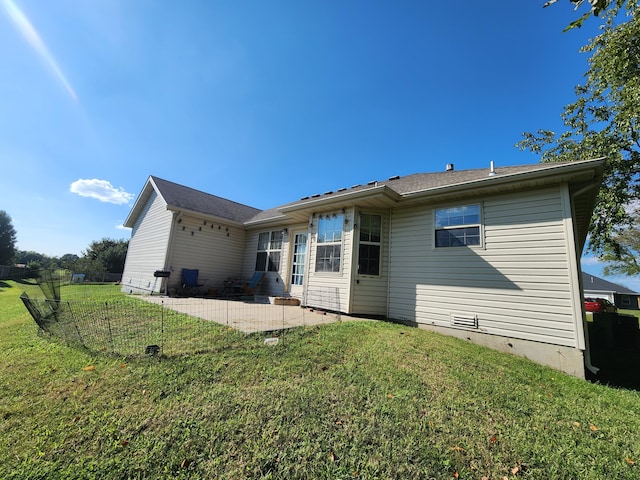 rear view of house featuring a yard and a patio