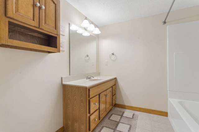 bathroom featuring shower / bath combination, baseboards, tile patterned flooring, a textured ceiling, and vanity