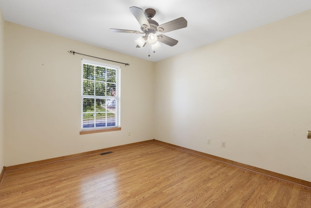 unfurnished room featuring baseboards, visible vents, a ceiling fan, and light wood-style floors