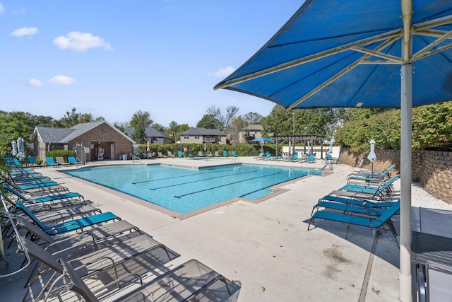 community pool with a patio area, fence, and a pergola