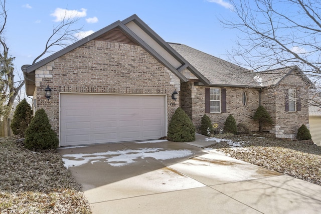 view of front of property with brick siding, driveway, an attached garage, and roof with shingles