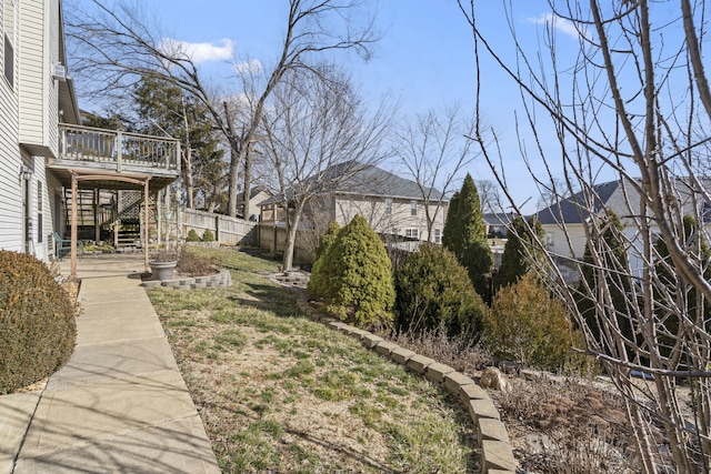 view of yard with a deck, stairway, and fence