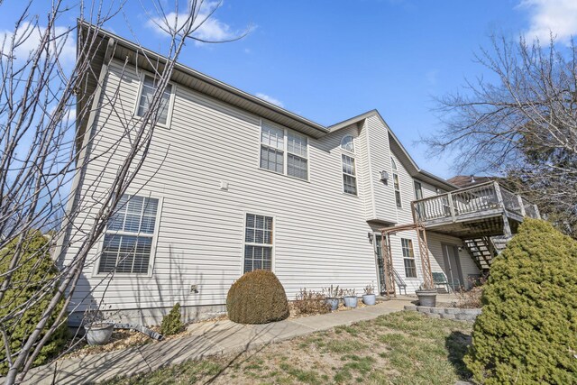 view of property exterior featuring stairway and a wooden deck