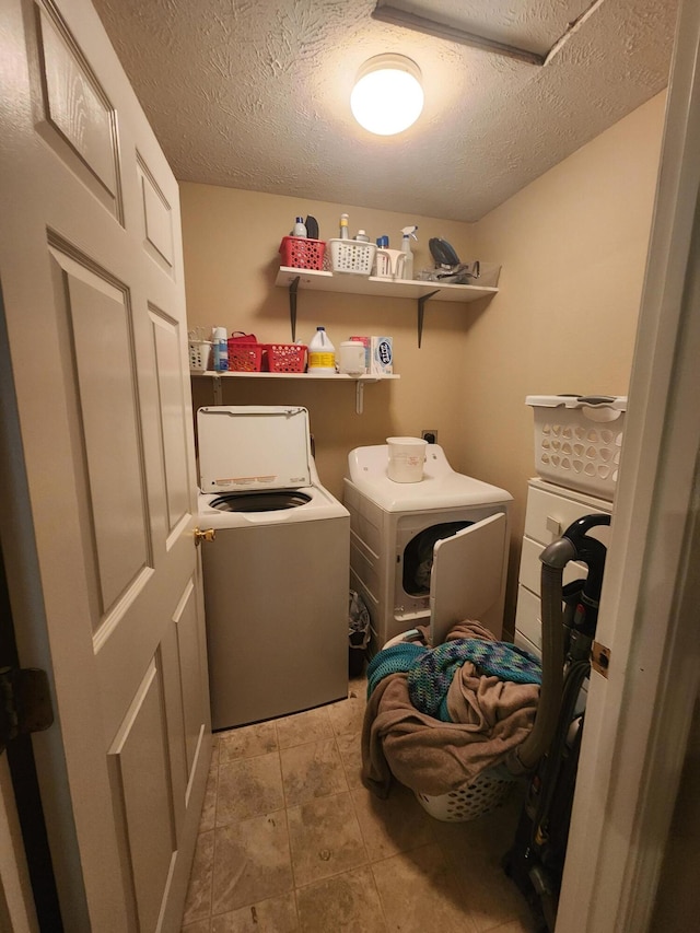 clothes washing area featuring washer and clothes dryer and a textured ceiling