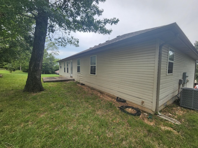 view of side of home featuring a yard and cooling unit