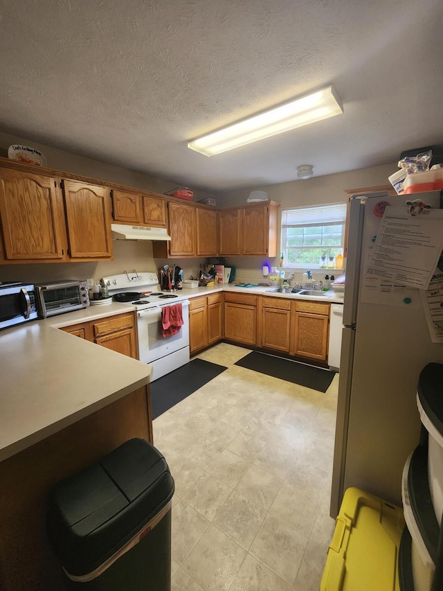 kitchen with white appliances, sink, and a textured ceiling