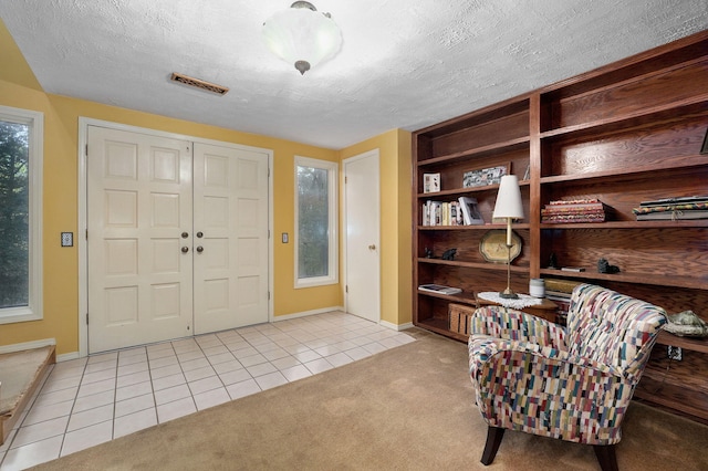 foyer entrance with a textured ceiling and light tile patterned floors