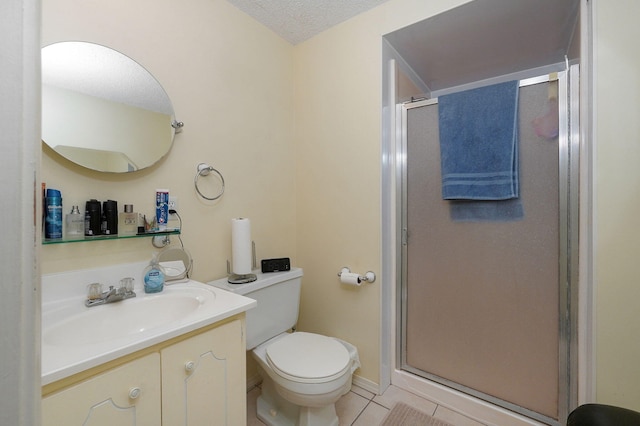 bathroom with vanity, a textured ceiling, tile patterned floors, walk in shower, and toilet