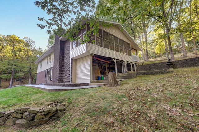 rear view of house with a sunroom and a yard