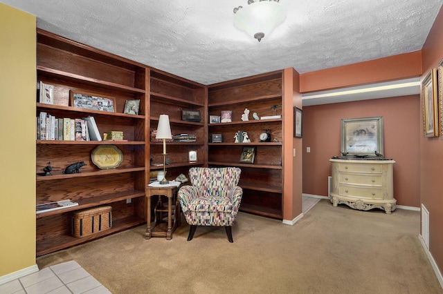 sitting room featuring light carpet and a textured ceiling