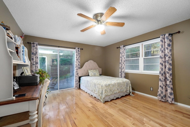 bedroom featuring access to exterior, ceiling fan, hardwood / wood-style floors, and a textured ceiling