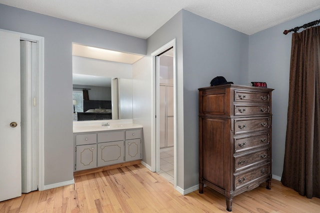 bathroom with hardwood / wood-style flooring, vanity, and a textured ceiling