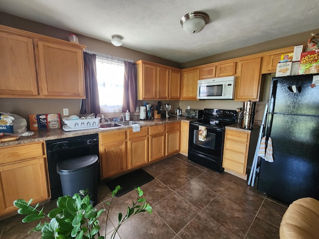 kitchen with black appliances, dark tile patterned flooring, sink, and a textured ceiling