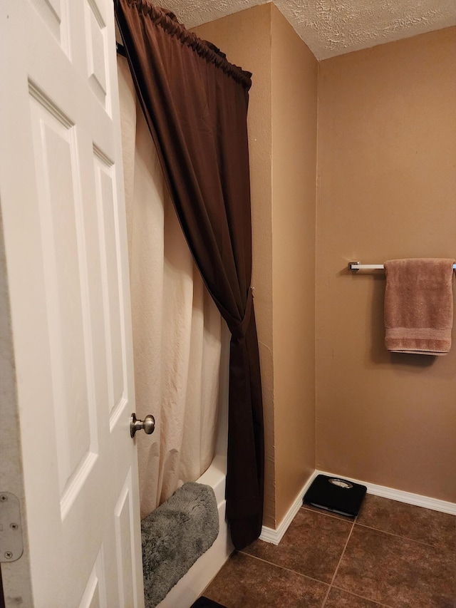 bathroom with shower / bath combination with curtain, tile patterned floors, and a textured ceiling